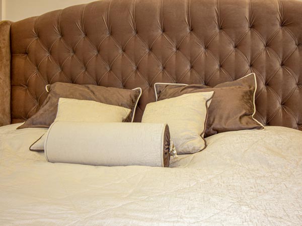 Шторы в спальню с покрывалом и подушками коричневого цвета